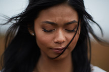 face of a young woman outdoors praying with closed eyes 