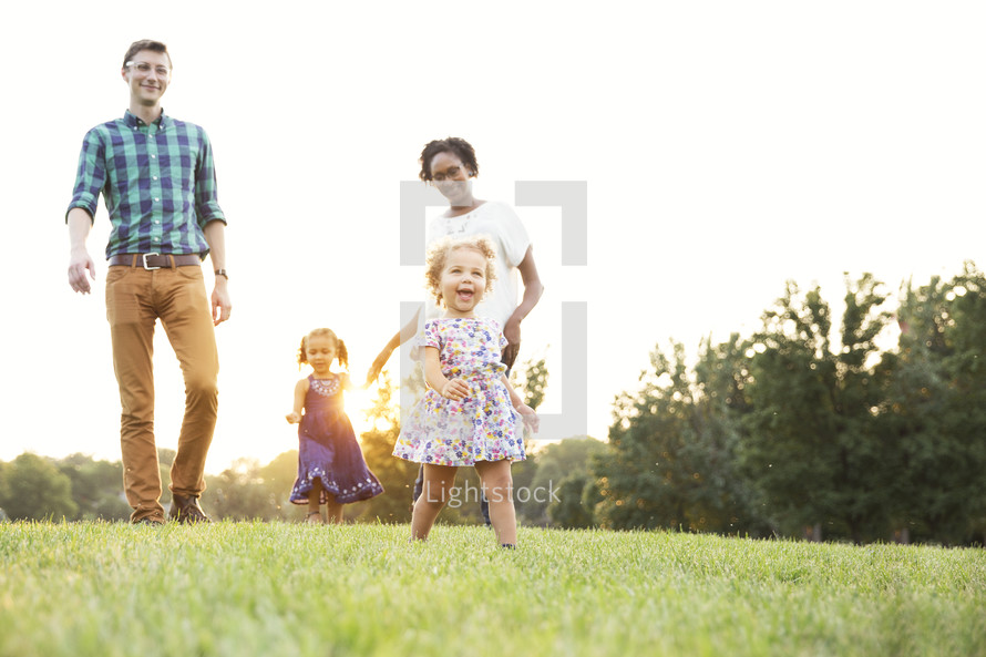 Mixed family walking and playing outdoors at sunset. 