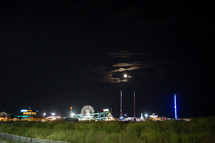 A full moon over a seaside amusement park 