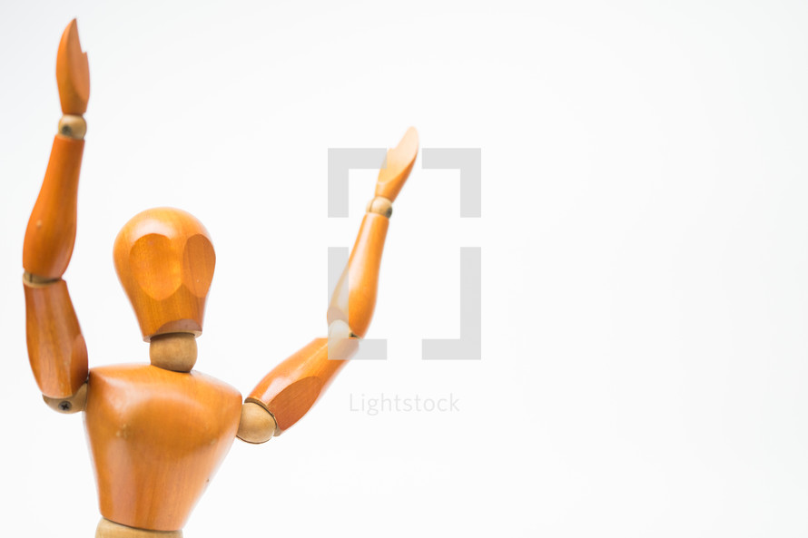 wooden mannequin with raised hands 