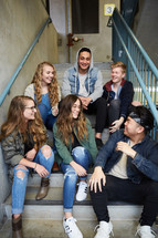 group of teens talking sitting on steps 