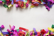 White paper bordered with colorful confetti. 