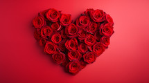 Red heart made of roses on red background.
