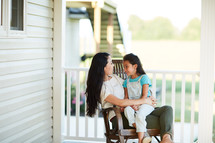 mother and daughter talking on the porch 