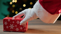 Santa Claus hand with red gift box