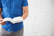 a man standing holding a Bible 