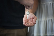 a man handing a key to a woman 