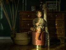 toddler boy sitting on a playroom stool 