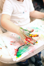 Boy painting with finger-paints