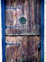 An old weather beaten wooden door framed with metal hinges. One cannot help but wonder what history this door has witnessed. I found this door to someone's home in historic Saint Augustine, Florida and just thought it had so much character and charm with its many colors and weathered exterior. 