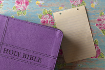 purple Bible and blank paper 