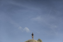 a man standing on top of a hill 