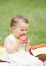 ittle girl eating a red apple