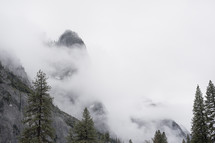 mountain peaks covered in fog and clouds 