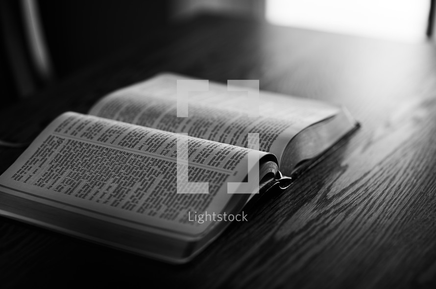 an open Bible on a wooden desk 