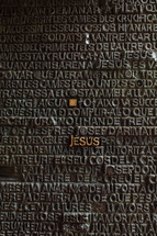 word Jesus standing out on a metal plaque 