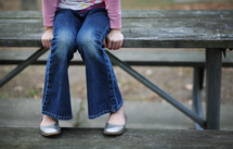 legs of a woman sitting on a bench