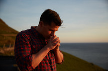 a man in praying at the shore 