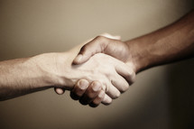 A handshake between a white and black man.