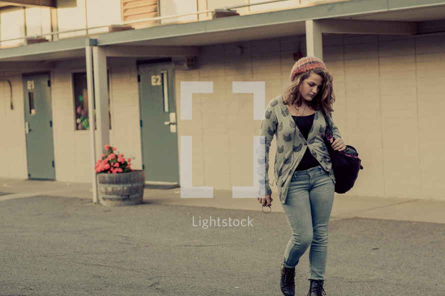Young Teenage girl walking alone on a school campus, sad, loneliness, student, youth
