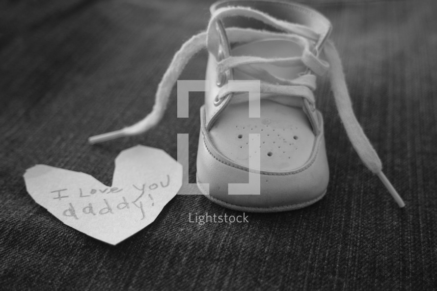 I love you daddy notes on a paper heart and an infant shoe 