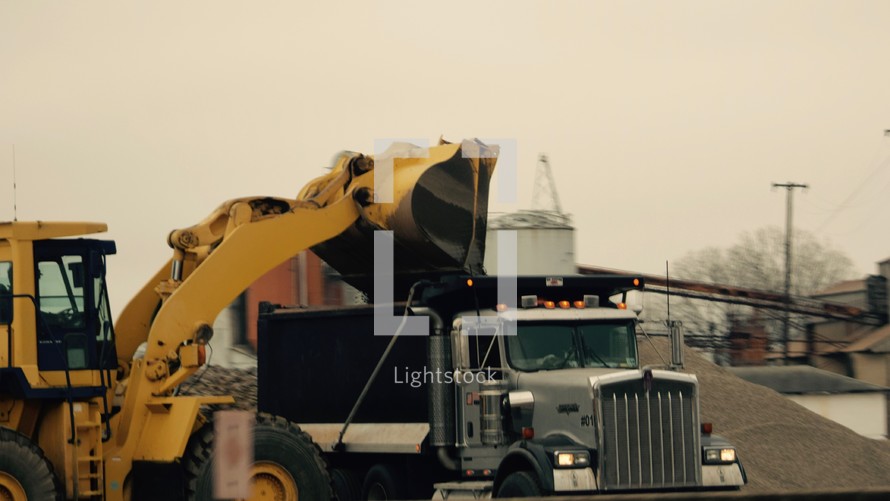 A front loader loading a dump truck 