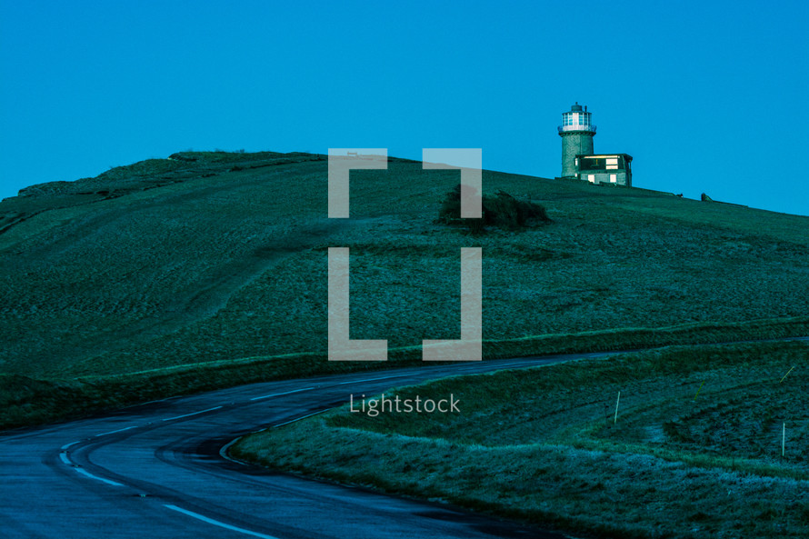 lighthouse on a grassy hill 