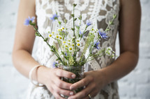 Woman holding bouquet of wildflowers. 
