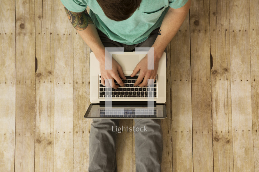 a man typing on a laptop computer.