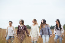 group of women walking through a field 
