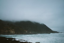fog over cliffs along a shoreline 