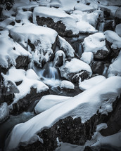 snow and flowing water in a stream 