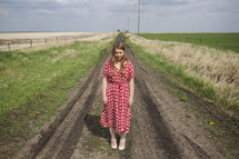 young woman alone on dirt road