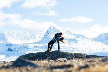 couple kissing in front of a snow covered mountain peak 