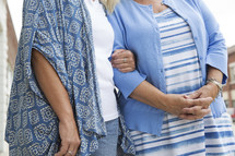 mother and adult daughter arm in arm 