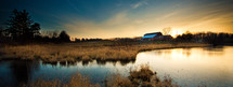 distant barn across a farm pond