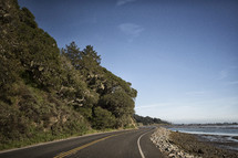 a curvy road along a coastline 