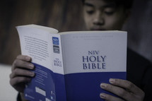 A young man reading a Bible.