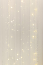 sparkling bokeh lights behind a sheer curtain 
