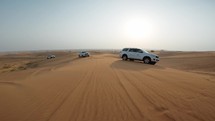Cars Driving Off In The Hot Desert