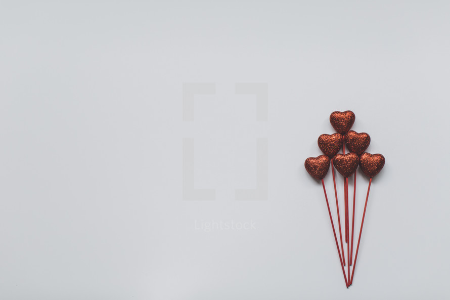 red hearts on sticks on a white background 