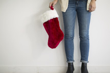 torso of a woman holding a Christmas stocking 