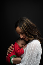 A mother holding a newborn close 