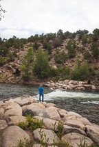 a man fishing in a mountain river 