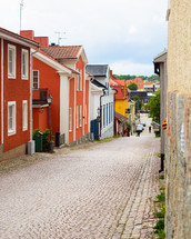 A cobblestone street running down through a city 