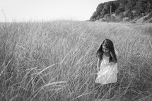 a girl in a field of tall grass