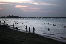 people on the beach at dusk 