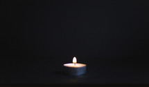 one single candle in dark room