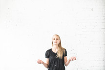 teen girl with hands raised in worship and prayer 