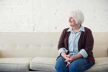 a woman sitting on a couch waiting 